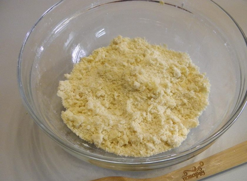 1. Этап. Королевская ватрушка с творогом: 3. Теперь сделайте основу ватрушки и верх. Для этого смешайте муку с сахаром, а потом перетрите эту массу со сливочным маслом. Холодное масло легко становится комочками. Главное работайте руками быстро, чтобы масло не таяло.