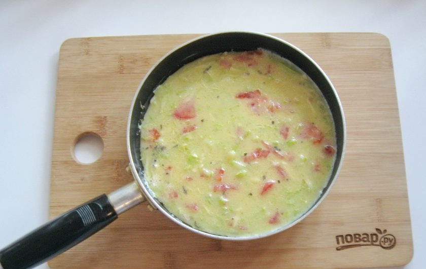 1. Этап. Омлет с сыром и кабачком: На горячую сковороду с подсолнечным маслом выложите яйца с молоком, кабачками, помидорами и сыром.