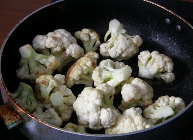 1. Этап. Цветная капуста жареная в сметане: Итак, разбираем цветную капусту на соцветия и хорошенько их промываем. Разогреваем масло на сковороде и жарим на нем капусту на среднем огне в течение 10 минут, периодически помешивая. Затем накрываем крышкой и еще некоторое время жарим до образования золотистой корочки.