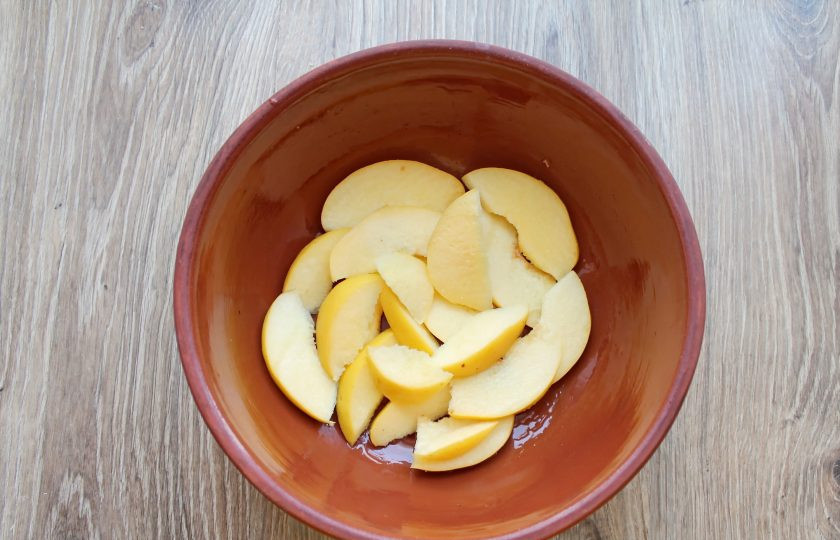 1. Этап. Мясо запеченное с фруктами: Айву вымойте, разрежьте пополам, удалите сердцевину и порежьте на дольки. Форму для запекания смажьте растительным маслом и выложите дольки айвы. Посолите и полейте соком лимона.