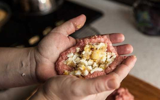 1. Этап. Зразы со свининой: 11. Выложите фарш на влажную ладошку и сформируйте лепешку. Заполните центр начинкой.