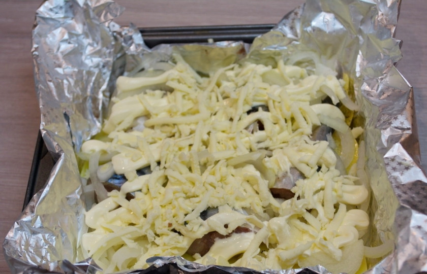 1. Этап. Скумбрия кусочками в духовке: Натрите на терке твердый сыр. Тончайшей струйкой полейте рыбку майонезом. Посыпьте сверху тертым сыром. Для посыпки я использовала сулугуни.