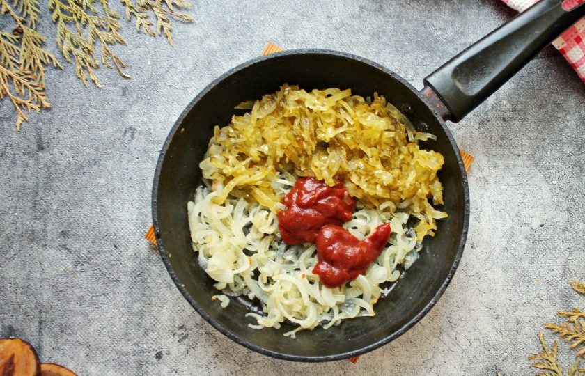 1. Этап. Солянка Московская: Соленые огурцы порежьте тонкой соломкой и вместе с томатом добавьте в сковороду с обжаренным луком. Все перемешайте и обжаривайте на среднем огне 7-8 минут.