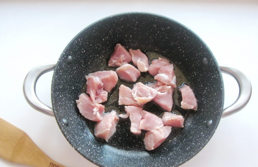 1. Этап. Солянка по-польски: Мякоть свинины помойте и нарежьте небольшими кусочками. Выложите на горячую сковороду или сотейник с подсолнечным маслом.