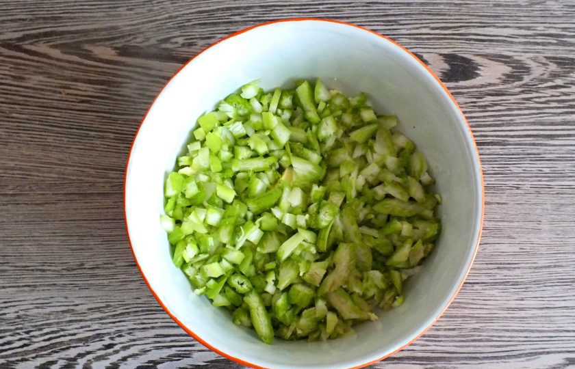 1. Этап. Салат с черешковым сельдереем и курицей: Черешки сельдерея вымойте, обсушите. Снимите грубые волокна. Нарежьте на мелкие кусочки. Добавьте в салатник.