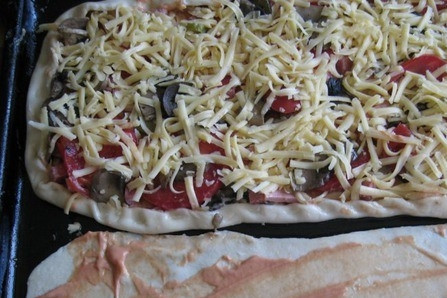 1. Этап. Пицца Ассорти: Нарежьте колбаску, сосиску, помидоры, с которых можно предварительно снять кожуру. Твердый сыр натрите на терке. Идеально подойдет Гауда. Смажьте тесто майонезом и кетчупом. Выложите начинку и присыпьте сыром. Также насыпьте ароматные специи.