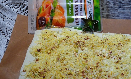 1. Этап. Слойки Ёлочки: Сыр натереть на мелкой тёрке, 2/3 посыпать на пласт теста, на сыр рубленые орехи, оставив немного. Слегка прокатать скалкой.