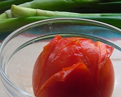 1. Этап. Соус к кальмарам: Для начала вам необходимо снять с помидора кожицу. Для этого сделайте на его носике крестообразный надрез лезвием ножа. Обдайте томат крутым кипятком, и тогда кожица снимется очень легко.