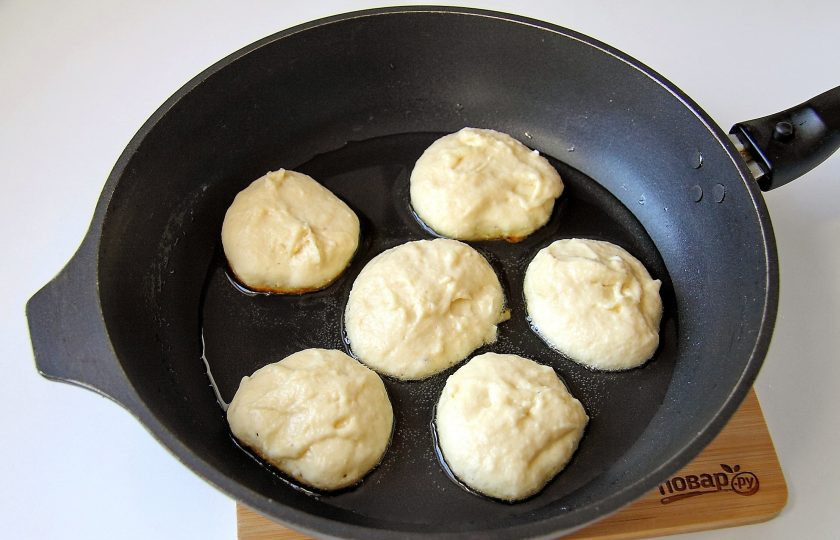 1. Этап. Пышные оладьи на кефире с манкой: Разогрейте сковороду с маслом и выкладывайте тесто при помощи столовой ложки, придавая оладьям необходимую форму.