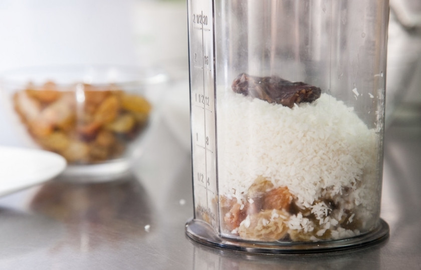 1. Этап. Домашние шарики Баунти (Bounty): Измельчите блендером кокосовую стружку, финик и изюм, постепенно добавляя молоко.