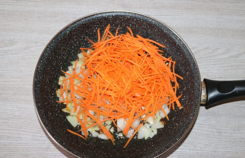 1. Этап. Экономный суп: Добавьте морковь к луку, обжаривайте вместе на медленном огне.
