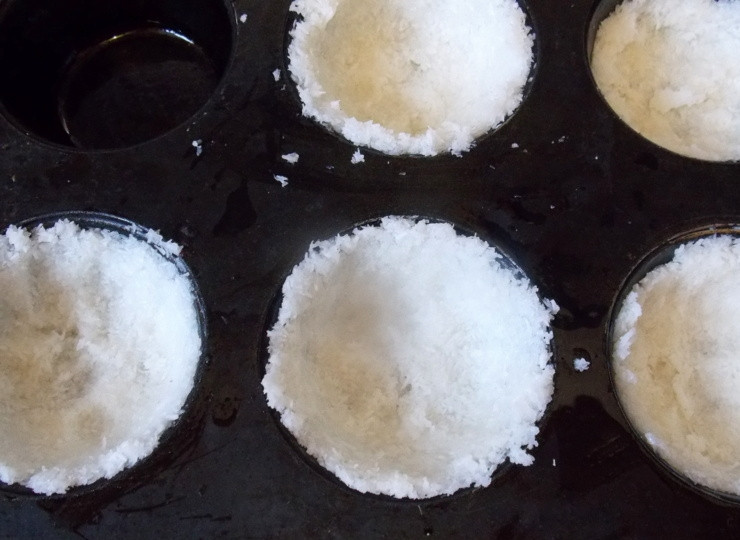 1. Этап. Кокосовые тарталетки с шоколадной начинкой: Форму с тефлоновым покрытием смажьте маслом. Положите 1 ст. л. массы в ячейку и равномерно распределите по стенкам и дну.