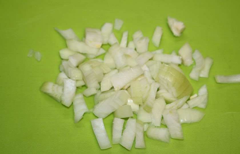 1. Этап. Фасоль с колбасками: Лук нарежьте кубиками.