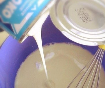 1. Этап. Пышки на сгущенке: Выливаем всю банку сгущенного молока и все это взбалтываем с помощью венчика.