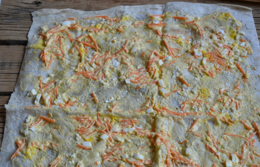 1. Этап. Рулетики из лаваша с корейской морковкой: Разложите лист лаваша на столе и равномерно смажьте его начинкой.