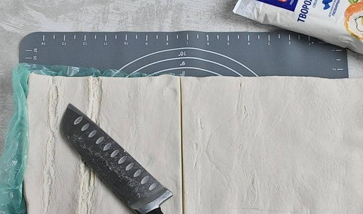 1. Этап. Слоеные корзиночки с чизкейком: 1. В оригинальном рецепте тесто делают с нуля. Я пользуюсь слоеным дрожжевым тестом из магазина. Разморозьте его на нижней полке холодильника и разрежьте пополам.