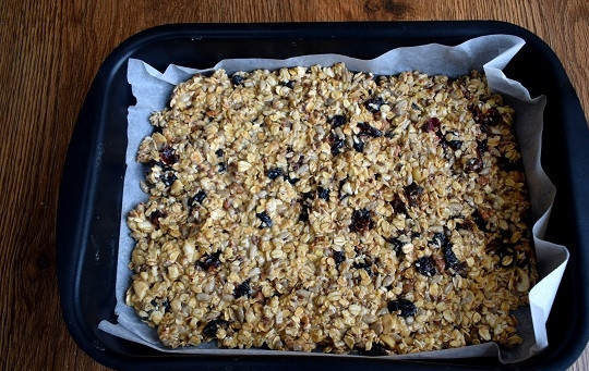 1. Этап. Батончики мюсли: Форму для запекания (22*30 см.) застелите пергаментом для выпечки. Выложите смесь, разровняйте, не сильно прижимая.