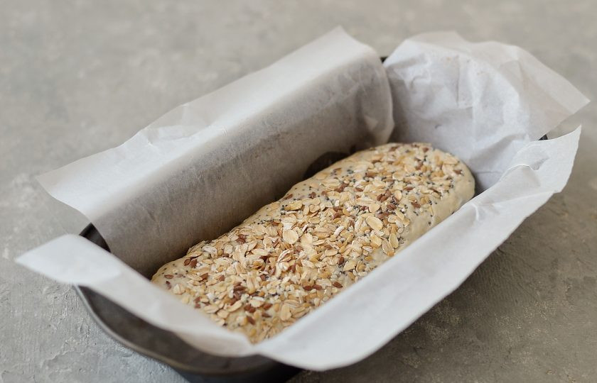 1. Этап. Злаковый хлеб в духовке: Смажьте форму для выпечки маслом или простелите пергаментом, выложите тесто, присыпьте сверху злаками. Оставьте подняться на 20-30 минут.