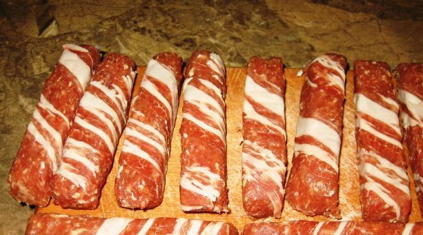 1. Этап. Большая сосиска в беконе: Оборачиваем сосиски беконом по косой. Лучше их заморозить перед жаркой.