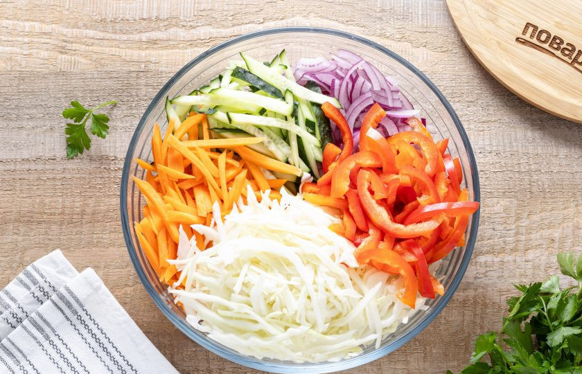 1. Этап. Овощное ассорти по-корейски: Капусту тонко нашинкуйте. Огурец, морковь и перец нарежьте соломкой, а красный лук полукольцами. Переложите в глубокую миску.