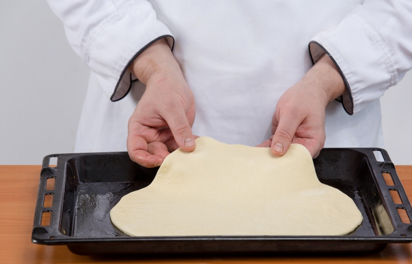 1. Этап. Тесто для пиццы за 5 минут: 5. Присыпаем стол мукой и раскатываем тоненькую лепешку из каждой половины теста. Тут теста хватит на две пиццы по 30 см в диаметре.