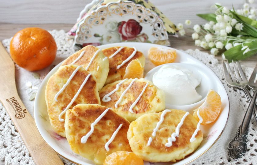 1. Этап. Сырники с мандаринами: Готовые сырники переложите в тарелку. Полейте сметаной или просто подавайте к столу горячими.