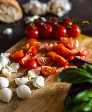 1. Stage. Bruschetta caprese: Separate the mozzarella by hand, cut the tomatoes into four parts.