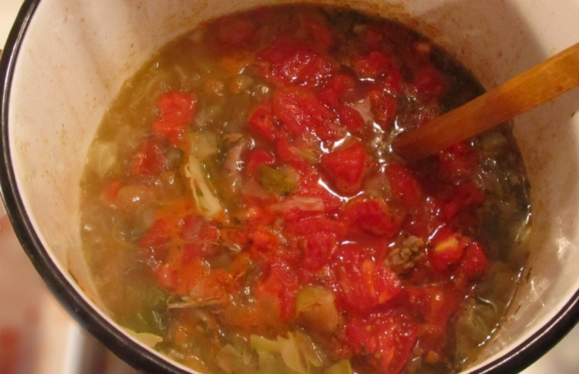 1. Этап. Томатный суп с капустой и мясом: Очистите помидоры от шкурки, для этого опустите их на минуту в кипяток. Шкурку будет легче снять. Затем разрежьте помидоры на четвертинки и добавьте к супу. Вылейте туда же вино и киньте лавровый лист. Добавьте нарезанные кусочки мяса. Посолите, поперчите по вкусу и варите ещё полчаса. Следите за тем, чтобы капуста не переварилась.