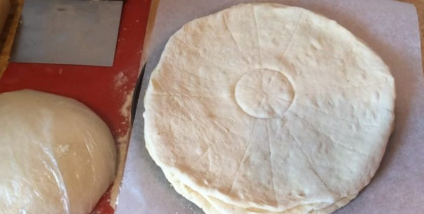 1. Этап. Булочки, политые шоколадом: Подровняйте его с остальными коржами, смажьте оливковым маслом, посыпьте сахаром и выложите сверху четвертый пласт. Разметкой разделите верхнюю лепешку на 16 частей, а стаканом наметьте по центру круг, который не нужно будет разрезать.