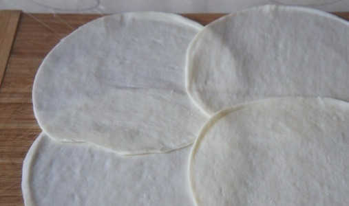 1. Этап. Cырные блины из сулугуни: Заранее сварите перепелиные яйца. 4 блинчика сулугуни уложите внахлёст на пищевую плёнку. Распределите крабовую начинку и яйца (вдоль). Заверните в рулет и уберите в холодильник.