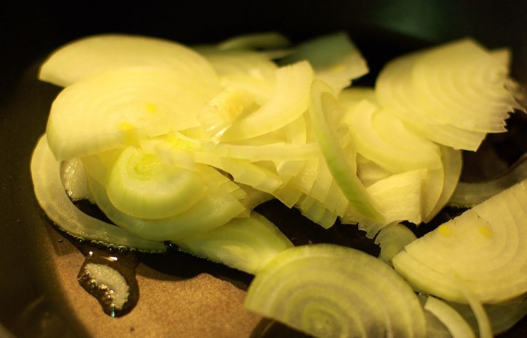 1. Этап. Антрекот из говядины: Лук нарезаем полукольцами и отправляем его на сковородку. Через несколько минут добавляем 100 мл вина.