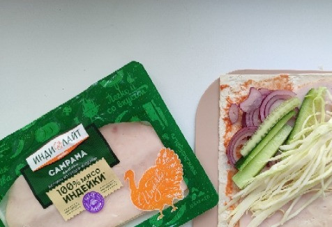 1. Этап. Рулет с ветчиной: Поверх выкладываем нарезанный лук, огурец, капусту.