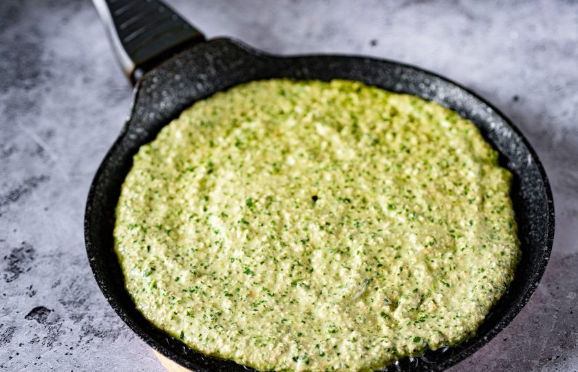 1. Этап. Овсяноблин со шпинатом: На среднем огне разогрейте сковороду с растительным маслом и выложите шпинатное тесто, разравнивая ложкой и формируя блин.