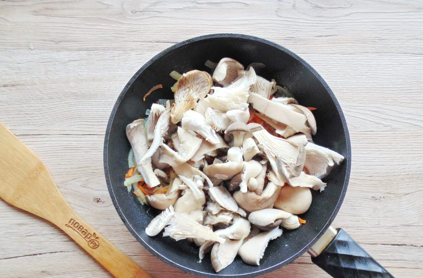1. Этап. Фунчоза с древесными грибами: У вешенок удалите ножки, нарежьте произвольно, но не крупно. Выложите в сковороду с обжаренными овощами и жарьте 5-6 минут, перемешивая.
