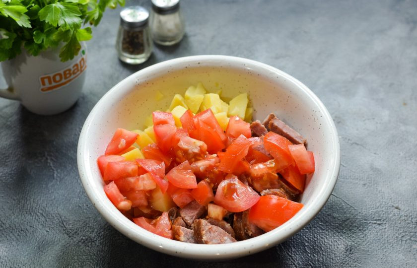 1. Этап. Салат Матадор: Помидор ополосните и просушите, нарежьте кубиками и добавьте в салат.