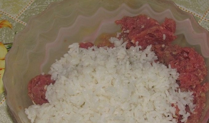 1. Этап. Тефтели с подливой в духовке: Для начала нам необходимо отварить рис, поэтому тщательно промываем его несколько раз, а затем ставим вариться на медленном огне. Когда рис будет на половину готов, выключаем огонь, сливаем с него воду и ждем, пока он немного остынет. Затем промываем его и смешиваем с мясным фаршем.