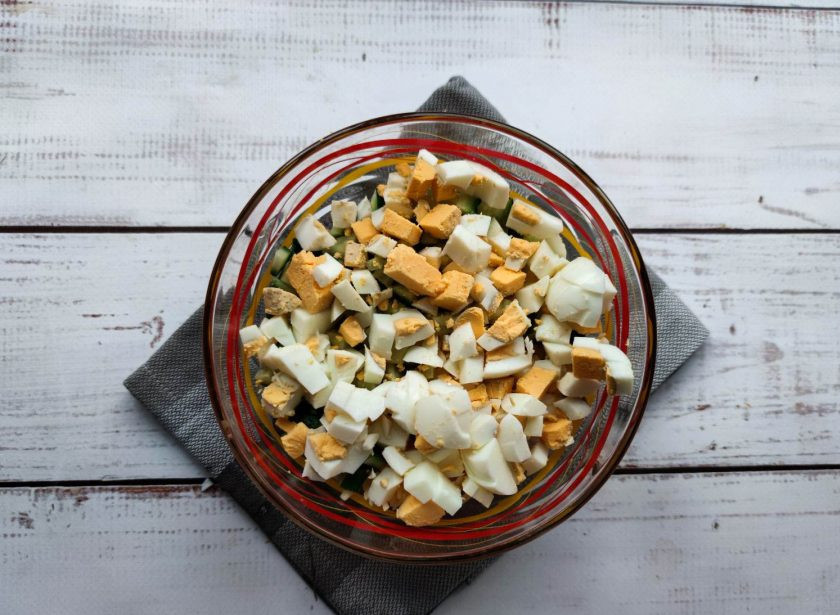 1. Этап. Салат Калейдоскоп с крабовыми палочками: Вареные яйца очистите от скорлупы, мелко нарежьте и добавьте к остальным ингредиентам.