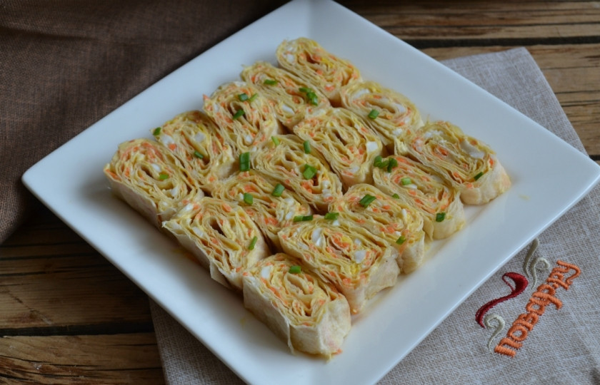 1. Этап. Рулетики из лаваша с корейской морковкой: Разрежьте рулет на небольшие кусочки, выложите на тарелку и украсьте зеленью. Закуска готвоа к подаче!