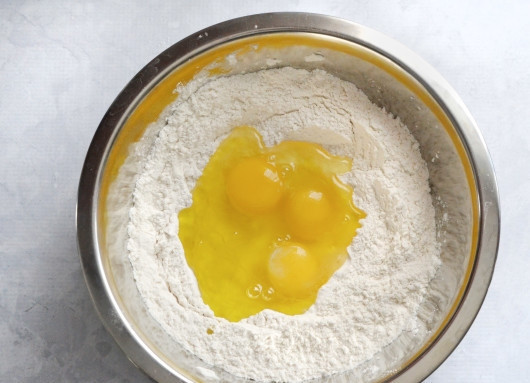 1. Этап. Макароны своими руками: 1. Муку и соль просейте в глубокую мисочку. В центре сделайте углубление, вбейте яйца и влейте масло.