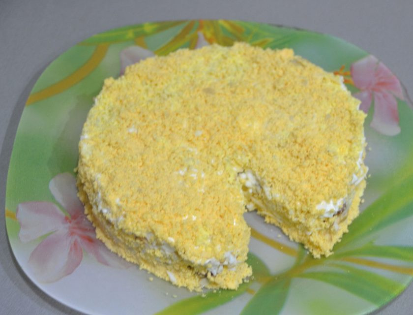 1. Этап. Салат Мышки-шалунишки: Аккуратно снимите кольцо, уберите вложенный кусочек сыра, посыпьте натертыми на терке желтками.