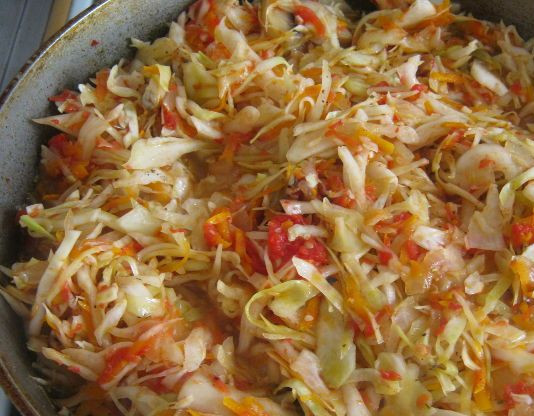 1. Этап. Тушеная капуста с шампиньонами: 4. После этого отправляем к грибам капусту с овощами. Заливаем половиной стакана воды и ставим тушиться. Готовим блюдо около 20 минут на слабом огне, постоянно помешивая.