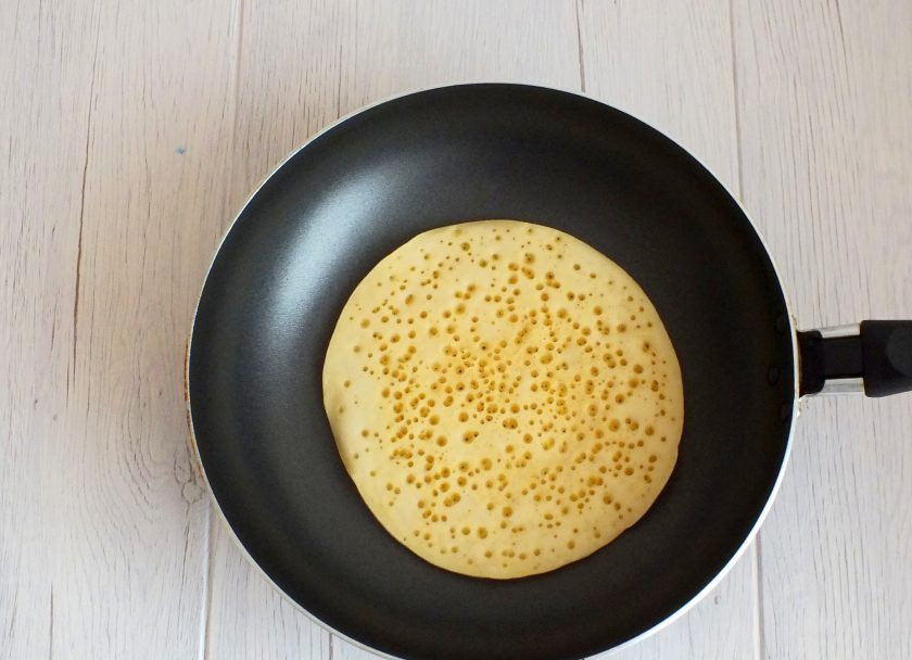 1. Этап. Блины на айране: На сковороду налейте порцию теста. Разровняйте с помощью половника. Обжарьте до появления мелких пузырьков-дырочек.