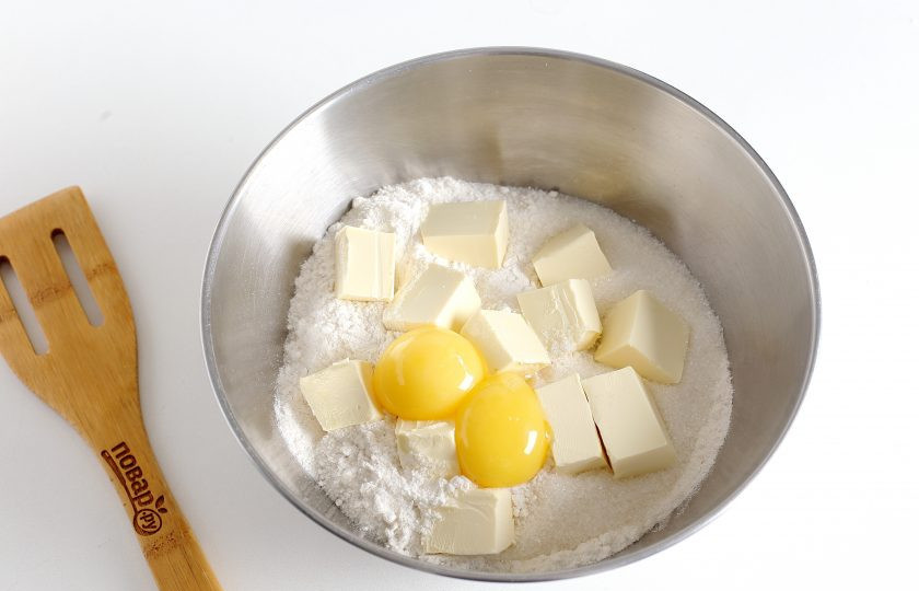 1. Этап. Песочный пирог: В глубокой миске соедините муку, нарезанное кубиками масло, соль, сахар и желтки.