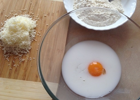 1. Этап. Овощные кексы: 4. Твердый сыр натираем на мелкой терке. В миске взбиваем-размешиваем яйцо с молоком.