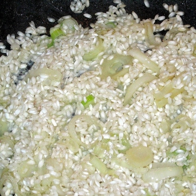 1. Этап. Ризотто с миндалем: Когда лук-порей станет мягким, добавляем в сковороду промытый рис и соль. Перемешиваем и обжариваем 3-4 минуты на среднем огне.