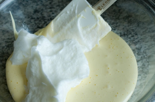 1. Этап. Бисквитный торт с шоколадом: 5. Треть белков переложите в желтки и аккуратно перемешайте лопаткой.