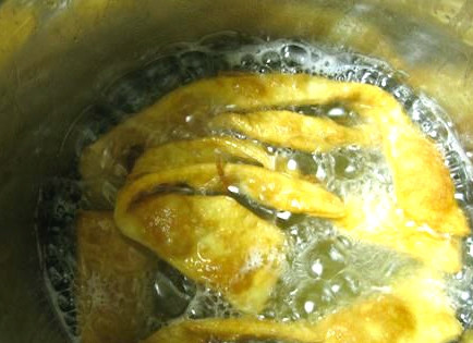 1. Этап. Хворост тонкий хрустящий на кефире: Нам понадобится сковорода с высокими краями. Также можно использовать кастрюлю и фритюрницу. Наливаем подсолнечное рафинированное масло, нагреваем на плите. Закладываем внутрь кусочки теста, обжариваем их с двух сторон.