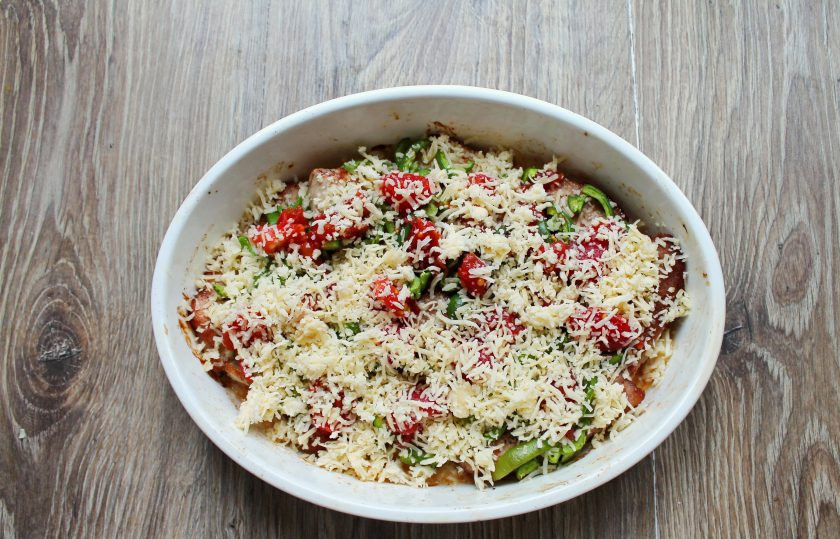 1. Этап. Свинина с маринованными помидорами: Сыр натрите на средней терке и посыпьте верх мяса и овощей.