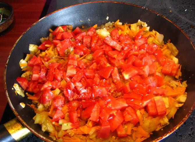 1. Этап. Лодочки из баклажанов в духовке: Ножом измельчаем мякоть баклажана. Затем обжариваем на растительном масле. Добавляем натёртую на крупной тёрке морковку и мелко порезанный лук и помидоры.