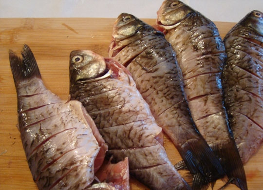 1. Этап. Жареный карась: 1. Карасиков лучше покупать одинаковых по размеру. Очищаем их от чешуи, разрезаем и изымаем внутренности, промываем рыбу. По обеим сторонам рыбы делаем надрезы с отступом 1 сантиметр, удаляем плавники.